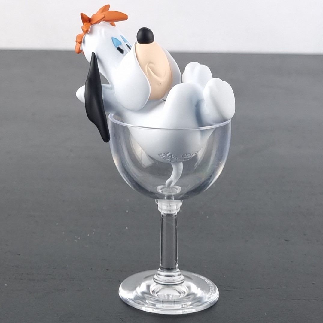 Droopy sitting in a glass figurine