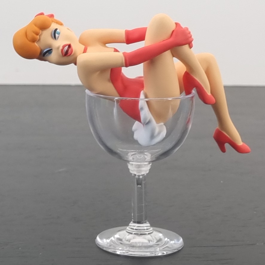 Red sitting in a glass figurine